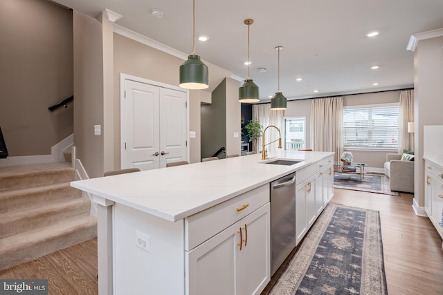 kitchen featuring a sink, dishwasher, wood finished floors, an island with sink, and recessed lighting