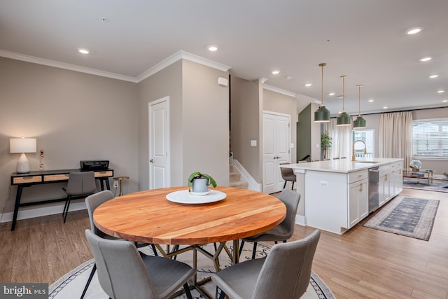 dining area featuring ornamental molding, light wood-style floors, stairs, recessed lighting, and baseboards