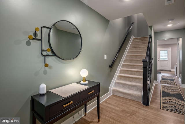 staircase featuring baseboards and wood finished floors
