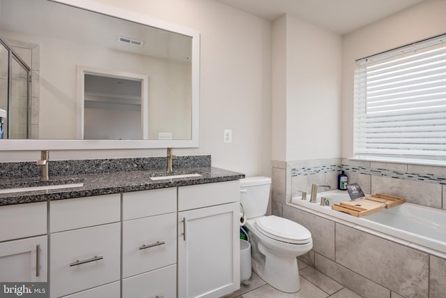 bathroom with toilet, double vanity, a bath, tile patterned flooring, and a tile shower