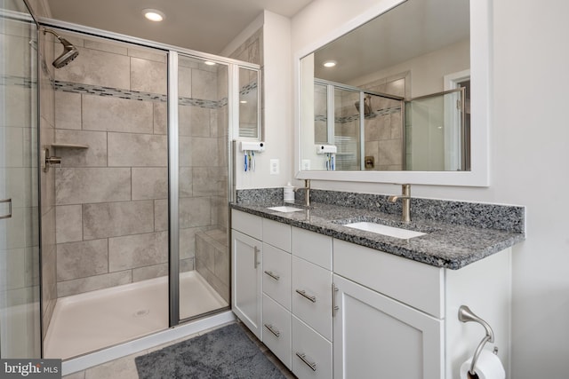 full bathroom featuring a stall shower, recessed lighting, double vanity, and tile patterned flooring