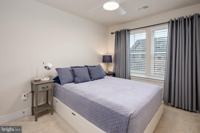 bedroom with light colored carpet, a ceiling fan, and baseboards