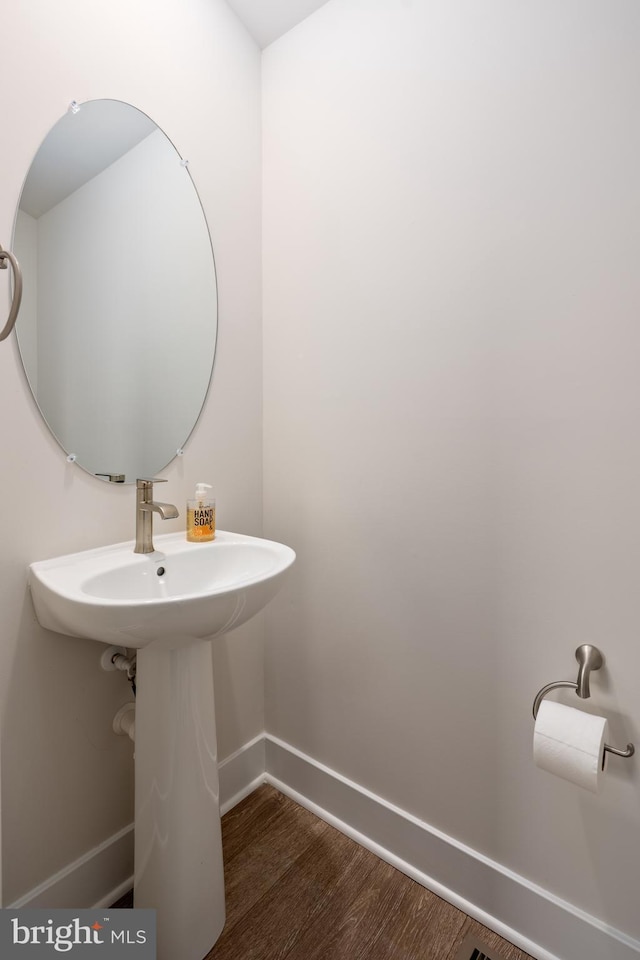 bathroom with baseboards and wood finished floors