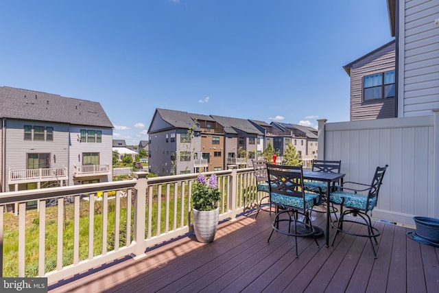 deck with a residential view and outdoor dining area