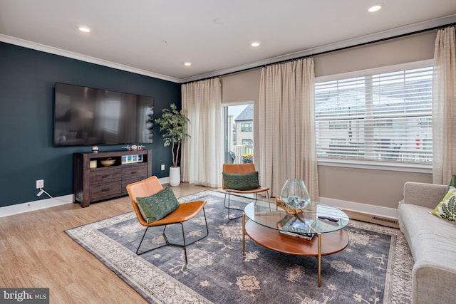 living area with wood finished floors, baseboards, crown molding, and recessed lighting