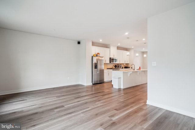 1724 Atlas Dr, Frederick, MD 21702 - unfurnished living room with a sink, light wood-style floors, recessed lighting, and baseboards