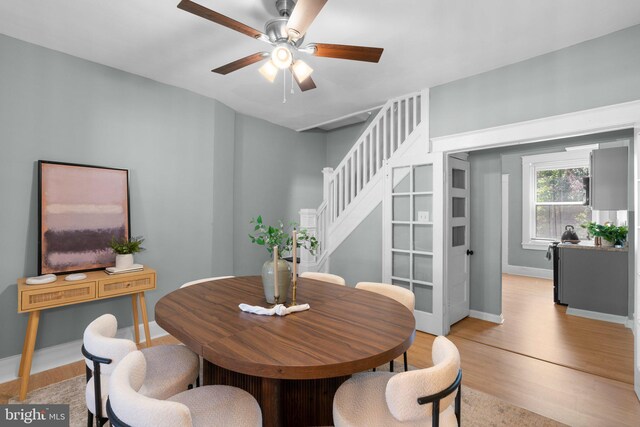 2719 Wilkens Ave, Baltimore, MD 21223 - dining area with a ceiling fan, light wood finished floors, stairs, and baseboards