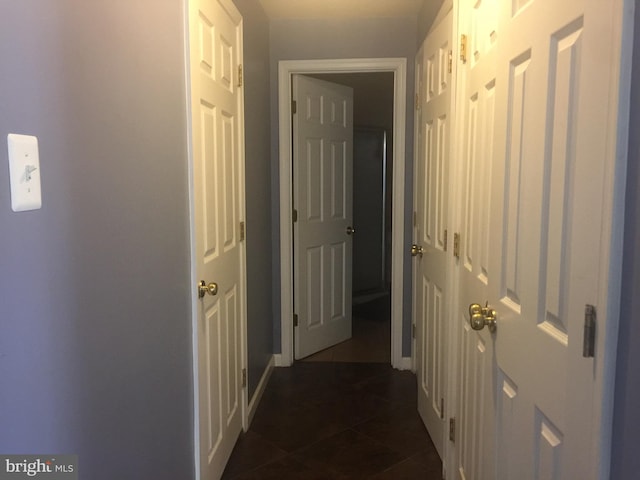 hall featuring dark tile patterned floors