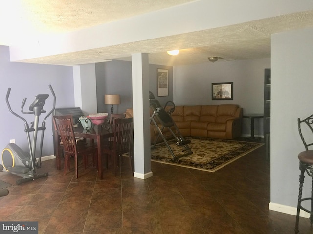 living area featuring a textured ceiling, baseboards, and tile patterned flooring