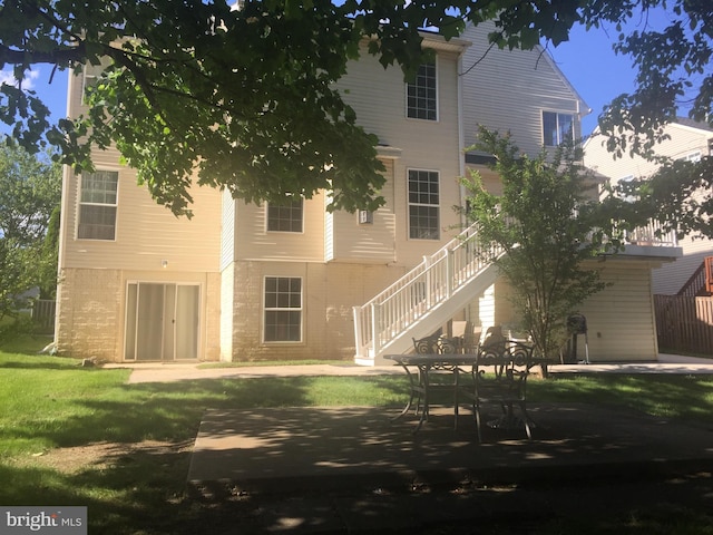 back of house featuring a yard, stairway, and a patio