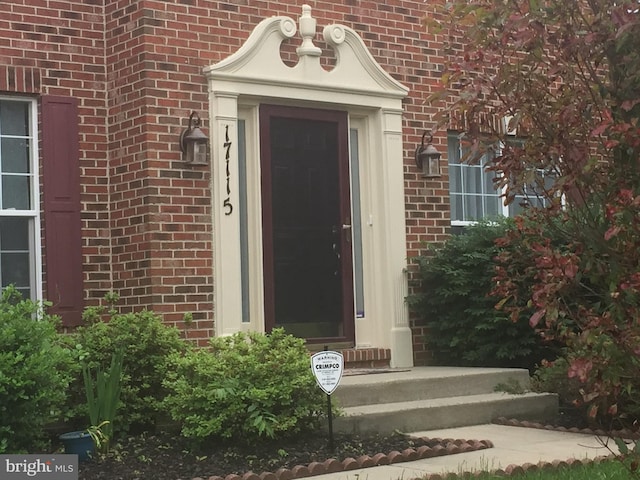 doorway to property with brick siding