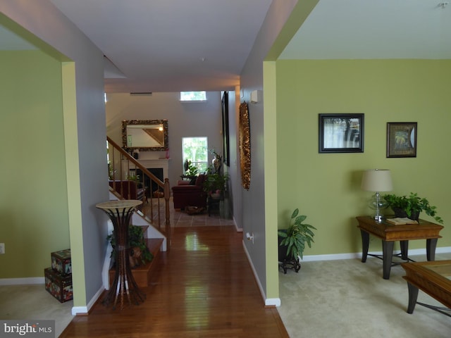corridor featuring stairs, baseboards, and wood finished floors