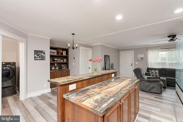 16155 Kerby Dr, Orange, VA 22960 - kitchen with a center island, washer / dryer, brown cabinets, light wood finished floors, and open floor plan