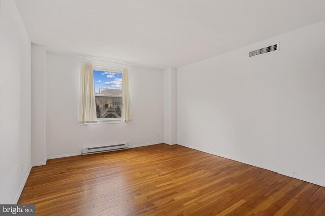 1101 Saint Paul St Unit 606, Baltimore, MD 21202 - spare room featuring baseboard heating and hardwood / wood-style flooring
