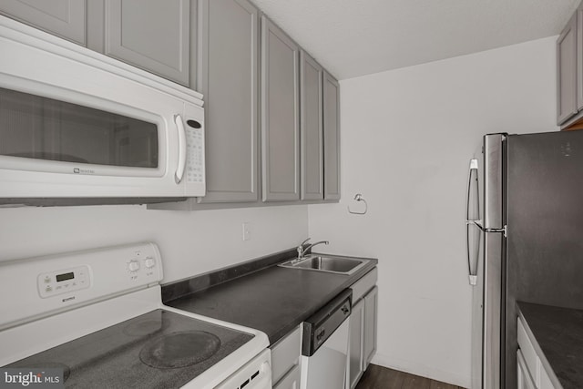 1101 Saint Paul St Unit 606, Baltimore, MD 21202 - kitchen featuring white appliances, a sink, dark countertops, and dark wood-style flooring