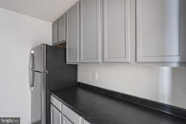 1101 Saint Paul St Unit 606, Baltimore, MD 21202 - kitchen featuring dark countertops, gray cabinetry, and freestanding refrigerator