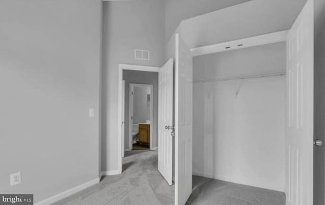 unfurnished bedroom with carpet flooring, a closet, and baseboards