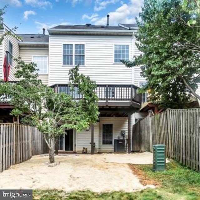 rear view of house featuring a wooden deck, a patio area, a fenced backyard, and cooling unit