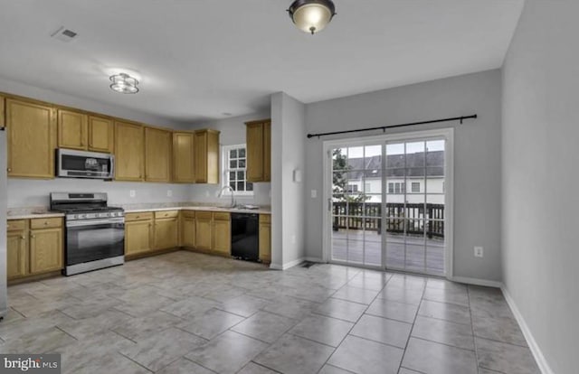 kitchen with appliances with stainless steel finishes, light countertops, and baseboards
