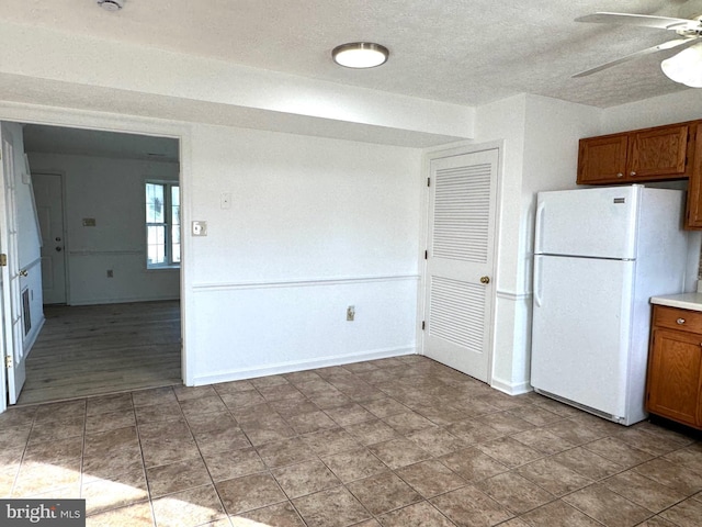 326 Banbury Ter, Winchester, VA 22601 - kitchen with freestanding refrigerator, a ceiling fan, brown cabinets, a textured ceiling, and baseboards