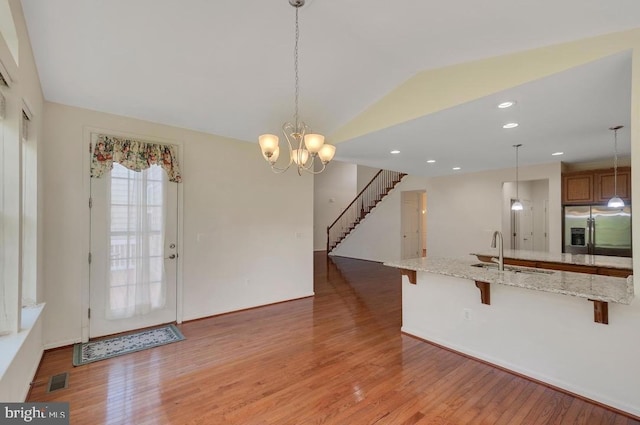 18776 Pier Trail Dr, Triangle, VA 22172 - kitchen featuring stainless steel fridge, a sink, light wood-type flooring, a breakfast bar area, and lofted ceiling