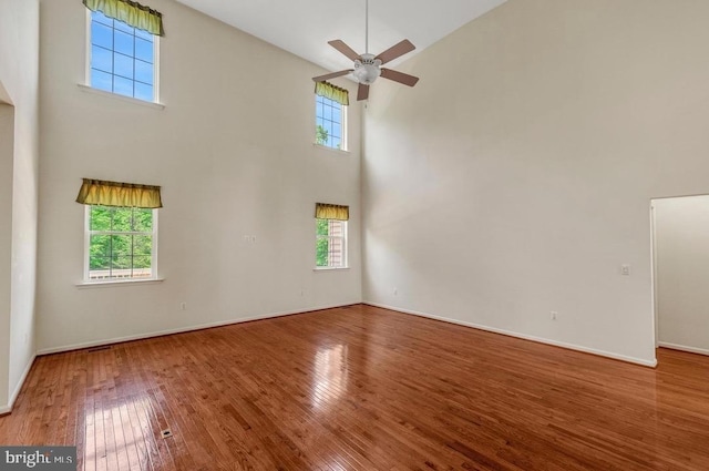 18776 Pier Trail Dr, Triangle, VA 22172 - unfurnished room with a towering ceiling, plenty of natural light, hardwood / wood-style flooring, a ceiling fan, and baseboards
