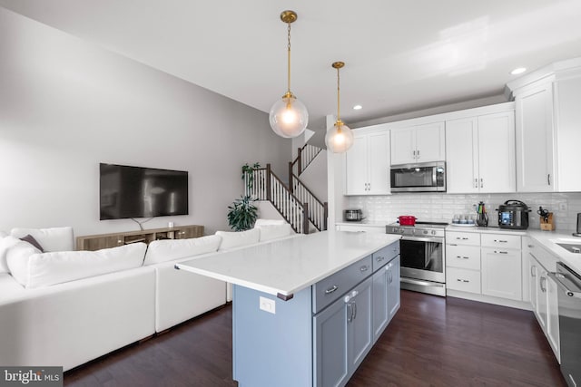 65 Tamarack Cir, Eagleville, PA 19403 - kitchen with stainless steel appliances, open floor plan, backsplash, light countertops, and white cabinetry
