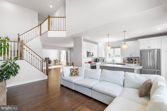 65 Tamarack Cir, Eagleville, PA 19403 - living room with stairs, dark wood-style flooring, recessed lighting, a high ceiling, and baseboards