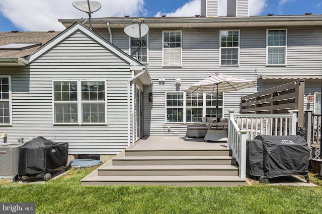 back of house with a wooden deck and a lawn