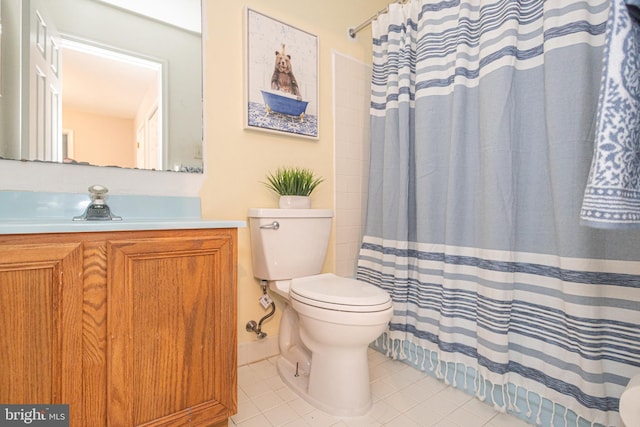 bathroom featuring tile patterned flooring, toilet, vanity, and curtained shower