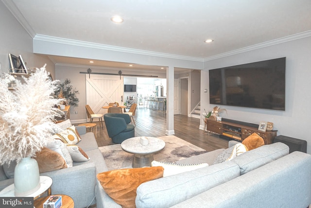 living area featuring a barn door, crown molding, stairs, wood finished floors, and baseboards