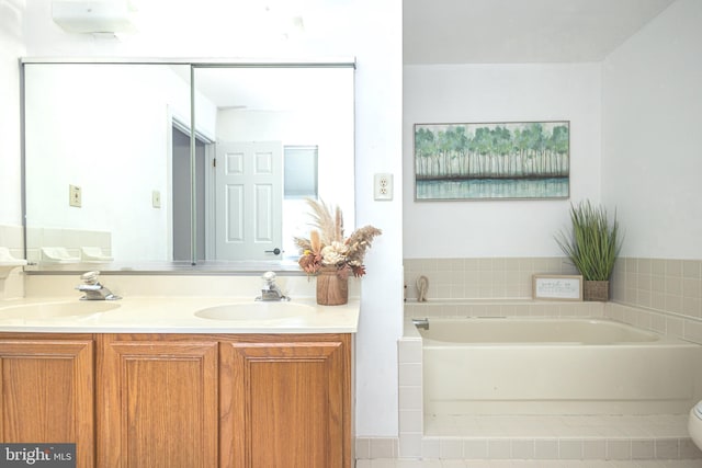 bathroom featuring double vanity, a bath, and toilet