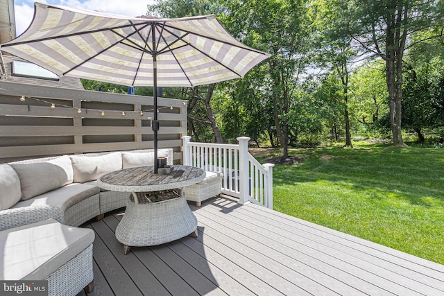 deck featuring a yard, an outdoor living space, and view of wooded area