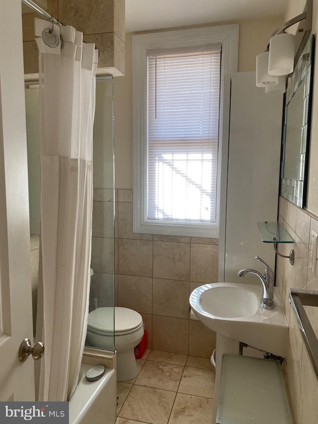 1858 California St NW Unit 33, Washington, DC 20009 - full bath with tile walls, shower / bath combination with curtain, tile patterned floors, and a wainscoted wall
