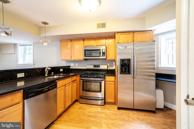 2510 Ontario Rd NW Unit 1, Washington, DC 20009 - kitchen featuring appliances with stainless steel finishes, a sink, light wood finished floors, and dark stone countertops