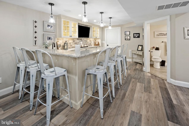 503 Dugout Dr, Lanoka Harbor, NJ 08734 - kitchen with baseboards, a peninsula, tasteful backsplash, glass insert cabinets, and wood finished floors