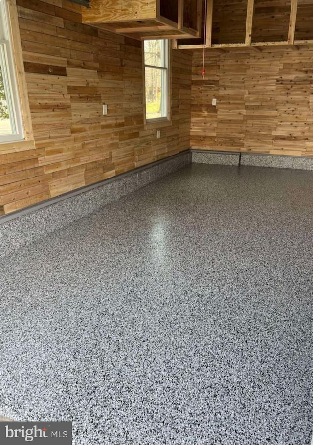 503 Dugout Dr, Lanoka Harbor, NJ 08734 - empty room with wood walls, speckle patterned floor, and healthy amount of natural light
