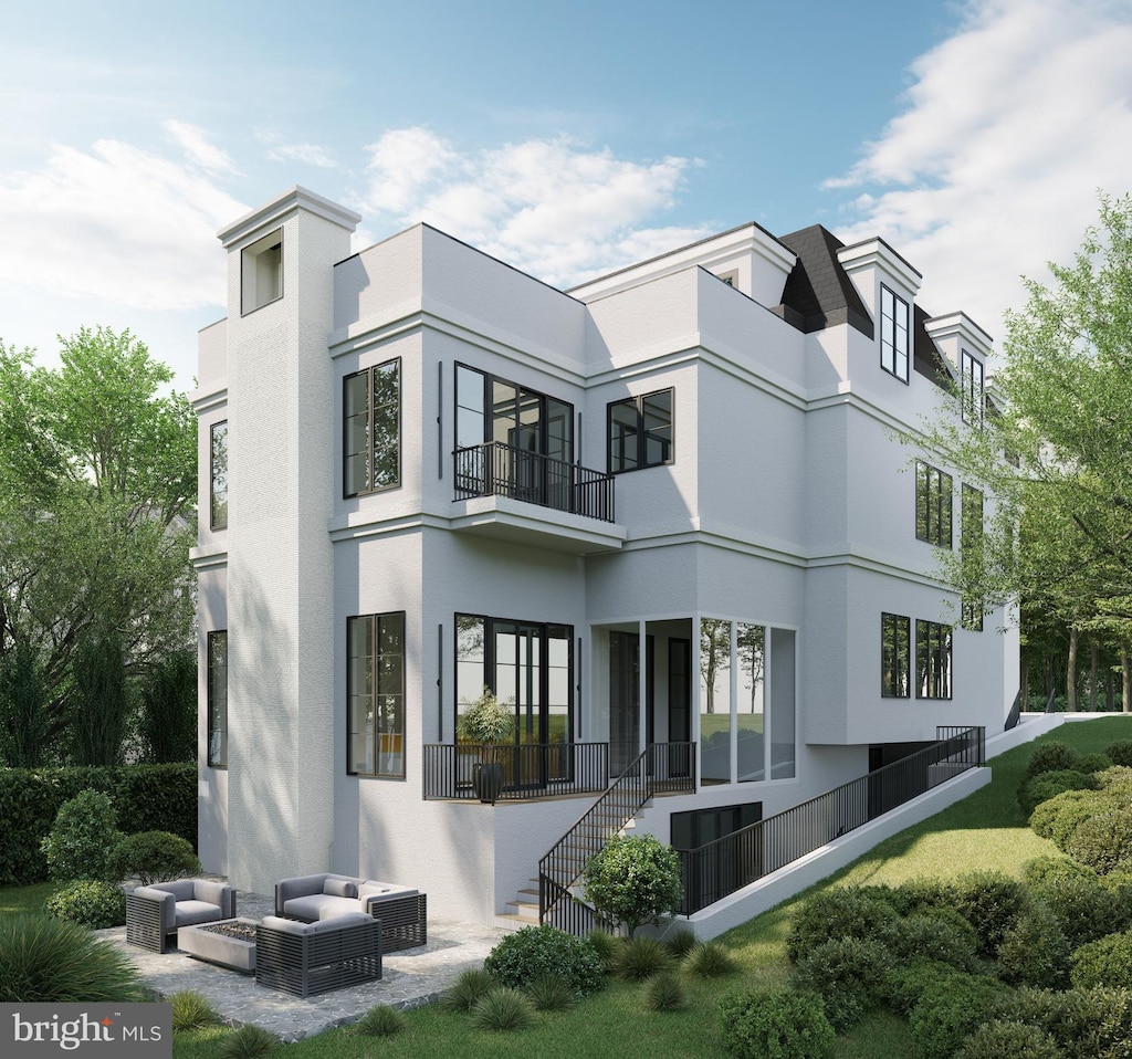5122 Cathedral Ave NW, Washington, DC 20016 - back of property featuring stucco siding, a balcony, and outdoor lounge area
