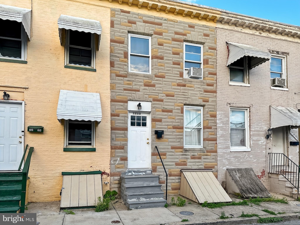 1213 N Spring St, Baltimore, MD 21213 - view of front of home featuring entry steps, stone siding, and cooling unit