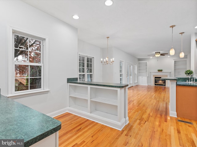 2411 Windwood Dr, Winchester, VA 22601 - kitchen with ceiling fan, dark countertops, a glass covered fireplace, light wood-style flooring, and recessed lighting