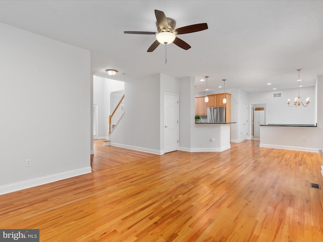 2411 Windwood Dr, Winchester, VA 22601 - unfurnished living room featuring light wood-type flooring, ceiling fan, stairway, a chandelier, and baseboards
