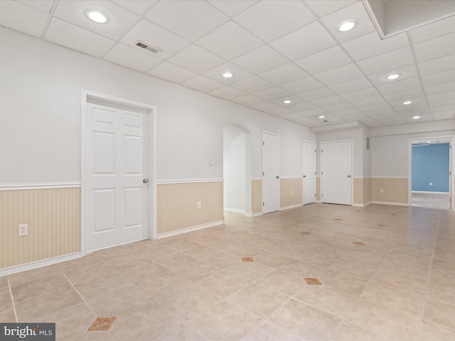 2411 Windwood Dr, Winchester, VA 22601 - empty room featuring wainscoting, arched walkways, recessed lighting, light tile patterned floors, and a drop ceiling