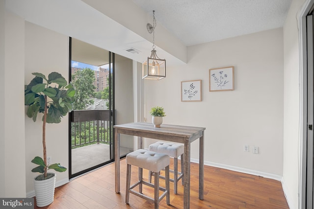 5300 Holmes Run Pkwy Unit 403, Alexandria, VA 22304 - dining area with wood finished floors, baseboards, a chandelier, and a textured ceiling