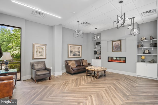 5300 Holmes Run Pkwy Unit 403, Alexandria, VA 22304 - living area featuring baseboards, a glass covered fireplace, a chandelier, and built in shelves