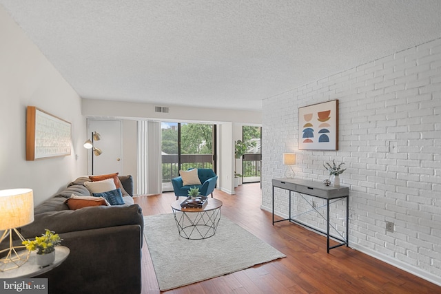 5300 Holmes Run Pkwy Unit 403, Alexandria, VA 22304 - living room with brick wall, a textured ceiling, wood finished floors, and baseboards