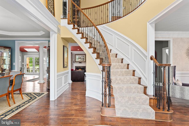 303 Greenbank Ln, Newtown Square, PA 19073 - stairway featuring decorative columns, wood finished floors, wainscoting, a decorative wall, and crown molding