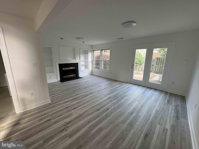 6325 Powder Flask Ct, Centreville, VA 20121 - unfurnished living room with baseboards, wood finished floors, a fireplace with flush hearth, and built in features