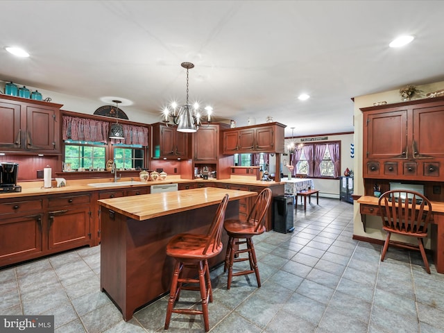 3622 Pricetown Rd, Fleetwood, PA 19522 - kitchen with butcher block countertops, a sink, a chandelier, pendant lighting, and a kitchen breakfast bar