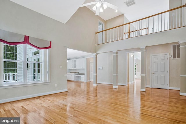 5257 Ferry Branch Ln, Lothian, MD 20711 - unfurnished living room with a towering ceiling, decorative columns, a ceiling fan, wood finished floors, and baseboards
