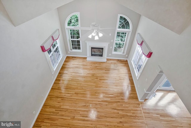 5257 Ferry Branch Ln, Lothian, MD 20711 - unfurnished living room featuring high vaulted ceiling, healthy amount of natural light, wood finished floors, ceiling fan, and baseboards